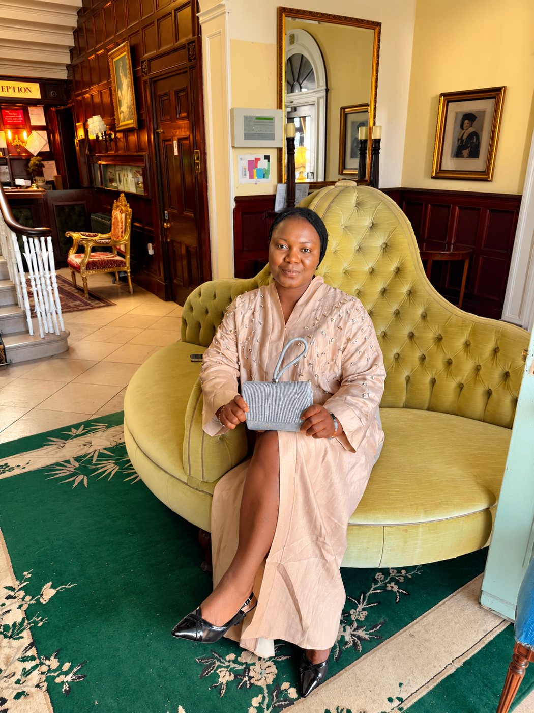 Esther seated elegantly in a hotel lobby